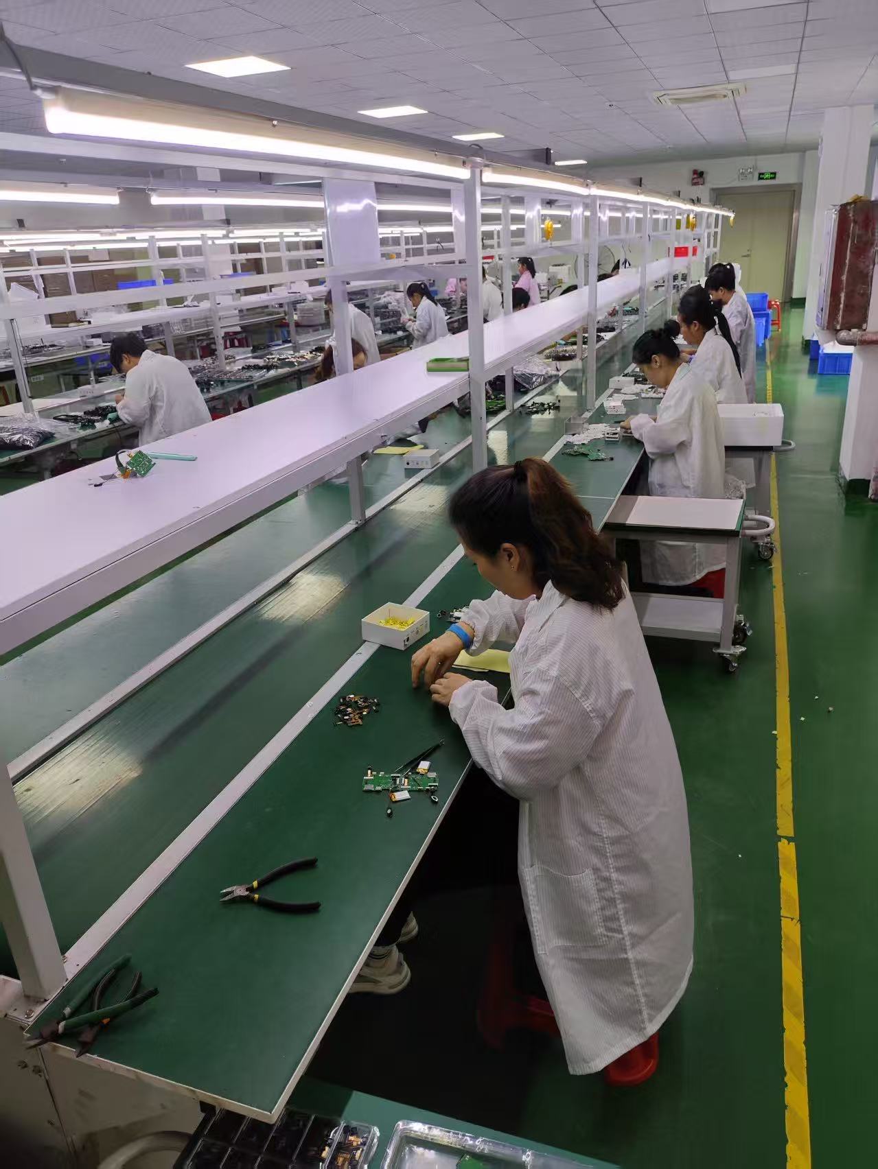 Workshop staff preparing camera circuit boards and parts for production